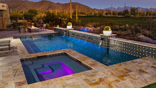 Desert pool and spa with water features at sunset