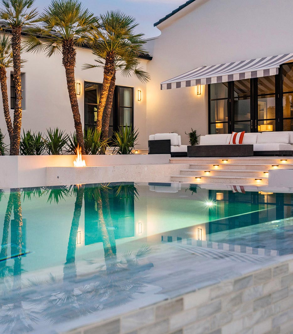 Twilight pool with baja tanning ledge and palms